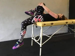 Test Thomasa – badana leży na krawędzi kozetki, jedno kolano przyciągnięte do klatki piersiowej, druga noga zwisa swobodnie